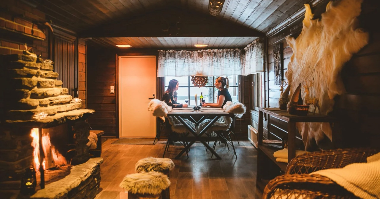 Tunnelmallinen ruokailuhetki hirsim&ouml;kin takkatulen &auml;&auml;rell&auml; Lapissa